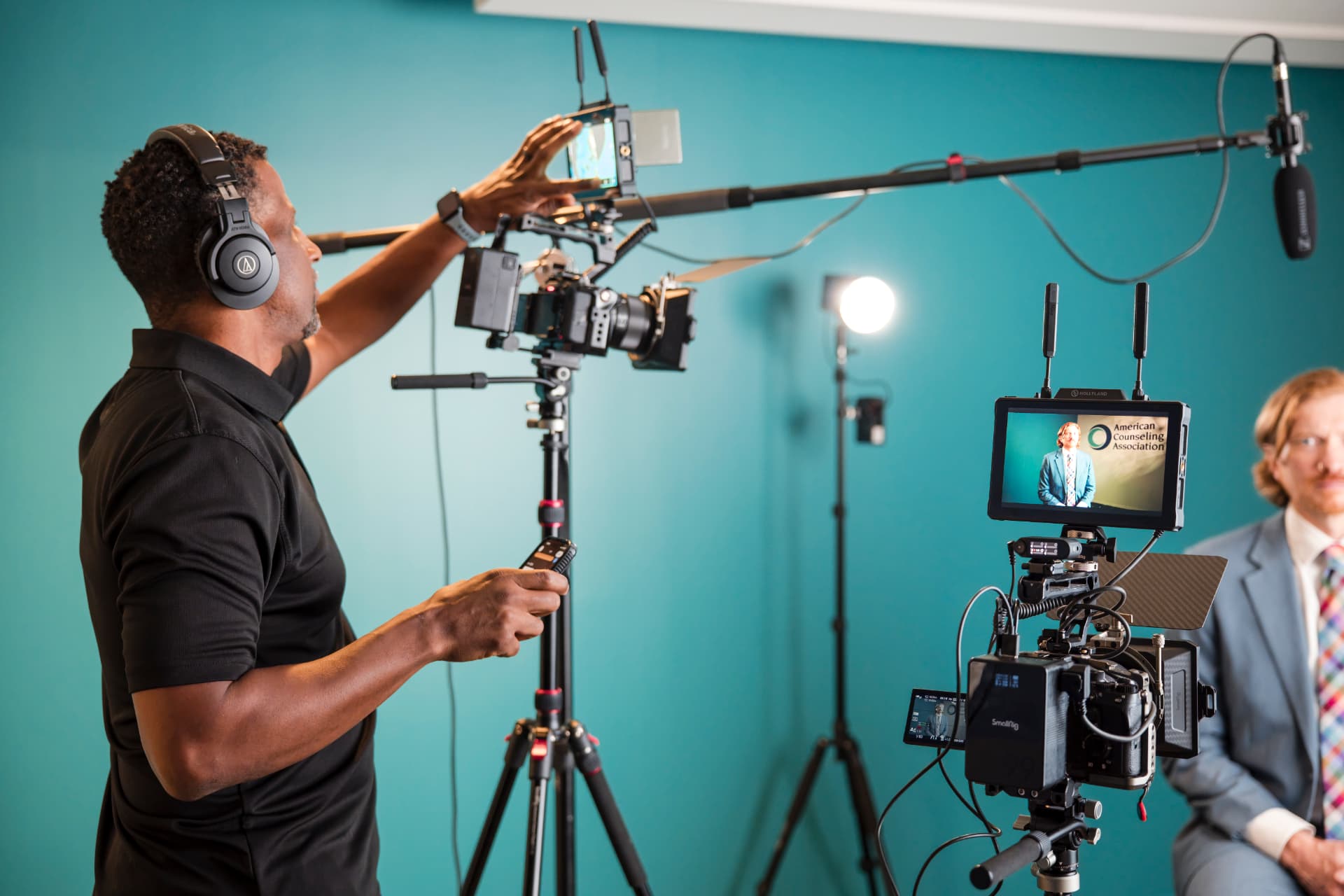 Boom operator and camera team framing a corporate interview